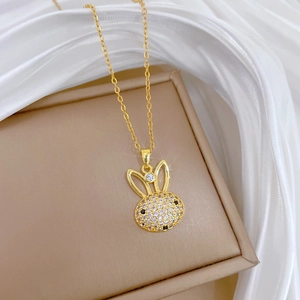 Gros plan du pendentif lapin doré avec strass sur un coffret à bijoux beige et soie