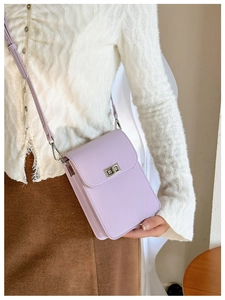 Close-up of lilac lychee grain phone bag with silver clasp on a knit cardigan
