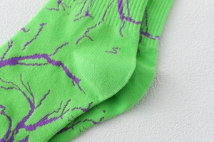 Détail de chaussettes en coton côtelé vert avec motif éclair violet et texture tricotée