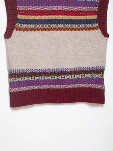 Detailed view of Fair Isle knitted vest showing colorful geometric patterns and ribbed hem