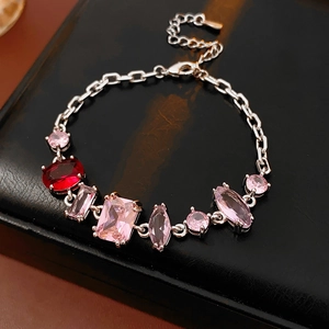 Close-up of vintage silver bracelet with pink and ruby zircon stones on black leather