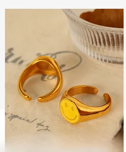 Macro view of 18K gold-plated smiley face rings on vintage paper background