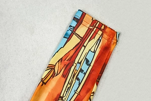 Macro shot of colorful printed dress fabric showing high-quality double-needle stitching