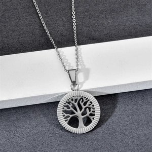 Silver stainless steel Tree of Life necklace with round pendant on textured surface