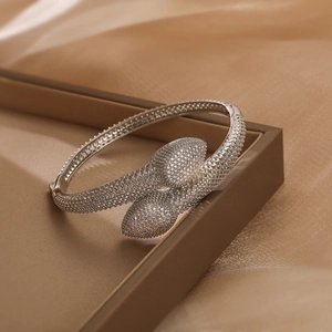 Luxuriöser silberner Zirkonia-Armreif im Crossover-Design auf Champagner-Seide