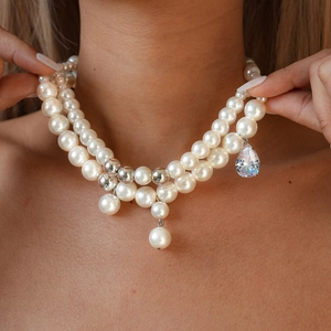 Detail of layered pearl necklace with silver beads and a zircon water drop pendant