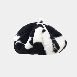 Close-up of soft plush cow print fabric texture and detailing on the fashion beret hat