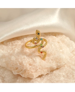 Macro detail of gold-plated snake ring featuring colorful inlaid stones and scales