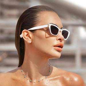 Fashionable white cat-eye sunglasses with dark lenses and a blue beaded necklace