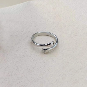 Close-up of S925 sterling silver hugging hands ring with detailed hallmark stamp