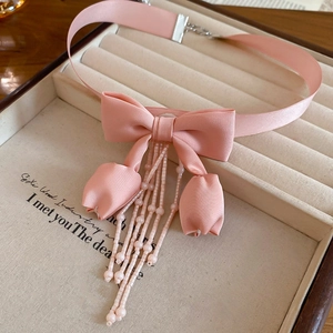 Detailed view of pink ribbon choker featuring elegant fabric tulip tassels and seed beads