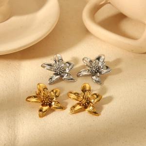 18K gold and silver plated flower stud earrings on minimalist beige background