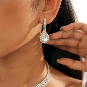 Détail de boucles d'oreilles goutte en argent avec diamants sur le profil d'une femme