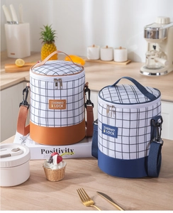 Detail view of cylinder insulated lunch bag with shoulder strap and plaid design