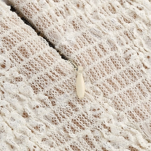 Close-up of fine lace texture and hidden zipper on this cream party dress