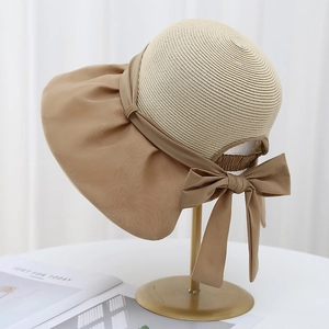Détail d'un élégant chapeau de soleil kaki avec grand nœud et bord large en satin