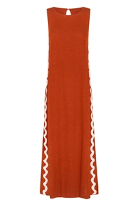 Detailed close-up of dark brick red sleeveless dress featuring white ric rac wavy trim
