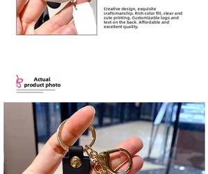 Close-up of cute cow keychain featuring custom leather strap and golden metal clasp