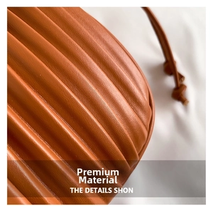 Macro shot of vertical pleated faux leather in caramel brown with drawstring detail