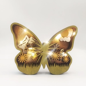 Detailed view of hollow wooden butterfly ornament with floral carving and warm LED lights