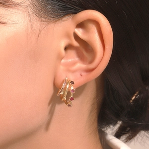 Close-up of gold multi-layer C-shaped earrings with pink zircon and micro-set stones