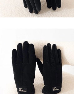 Detail of black windproof winter gloves with white textile logo label on the cuff