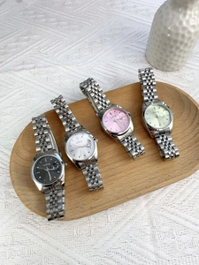 Classic ladies watches with colorful dials on a wooden tray with elegant metal straps