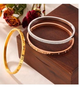 Detailed macro view of gold, rose gold and silver bracelets with Roman numerals and diamonds