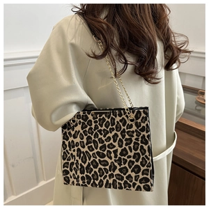 Close-up of leopard print tote bag featuring textured fabric and golden chain strap