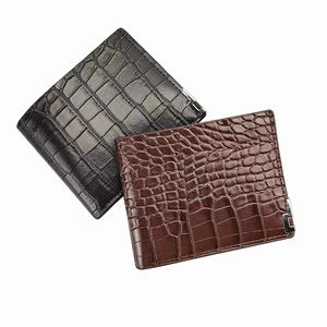 Close-up of black and dark brown crocodile pattern wallets with silver corner accents