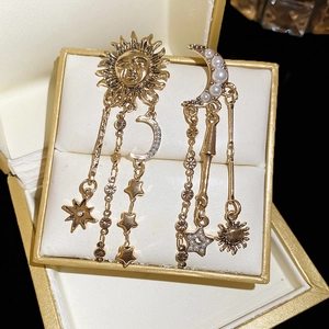 Detailed macro view of bohemian sun and moon fringe earrings with pearls in a jewelry box