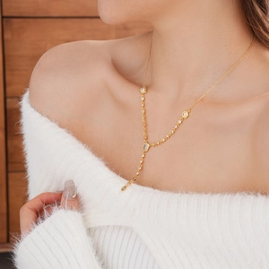 Detail view of gold-plated Y-shaped necklace with oval zircon on a female model