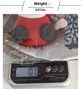 Mesure du poids de la chaussette de Noël affichant 107g sur une balance électronique