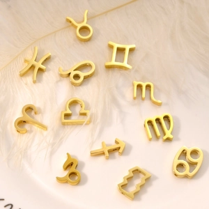 Golden zodiac sign pendants set in stainless steel for DIY jewelry on white feathers