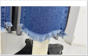 Detail van blauwe jeans met gerafelde zomen en onafgewerkte franjes in close-up weergave