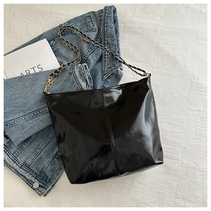 Glossy black patent leather tote bag with chain strap and vertical stitching detail