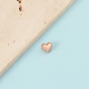 Detail of rose gold heart bead with beaded edges and hole for DIY jewelry making