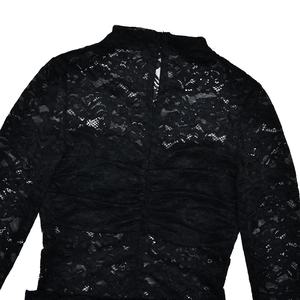 Detail of sheer black lace fabric with intricate floral patterns and ruched texture details