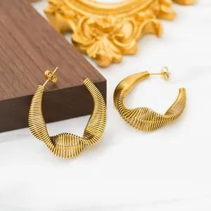Macro detail of 18k gold plated stainless steel spiral spring hoop earrings with C-shape