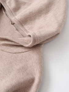 Close-up detail showing the soft knitted texture and fine stitching of the beige tracksuit