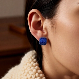 Detail of vintage blue zircon square stud earrings worn on model for a retro look