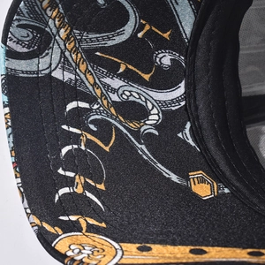 Detail of baseball cap brim with gold baroque scrolls and precision stitching