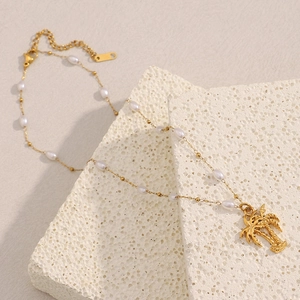 Close-up of 18K gold-plated coconut tree pendant with small white pearls on stones