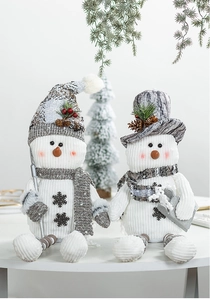 Close-up of Nordic Christmas snowman figures with knit hats and festive berry accents