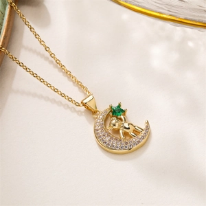 Detail of gold plated bear necklace with crescent moon pendant and green star gemstone