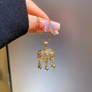 Detail showing gold longevity lock pendant with hollow filigree and zircon stones