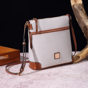 Close-up of pebble grain texture on light grey crossbody bag with brown leather trim