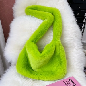 Macro shot of fluffy fluorescent green faux fur tote bag with wide shoulder strap