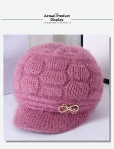 Detail of pink knitted winter hat for elderly women with rhinestone bow and fur texture