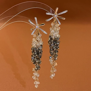 Detailed macro view of long tassel earrings with gradient beads and clear cubic zirconia